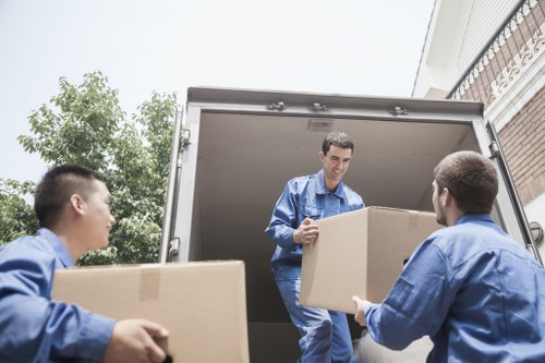 Professional moving team handling boxes with a removal van